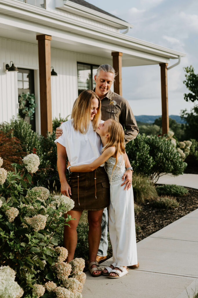 family stands in front of their home for a photo session