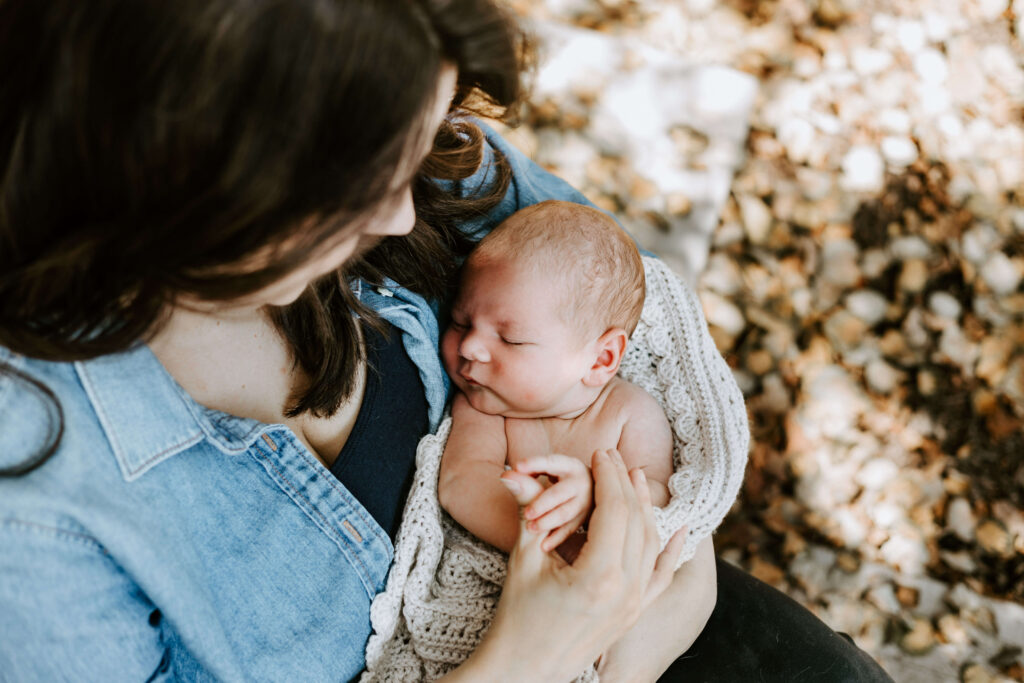 Mom holding newborn baby outside of their home in Greensburg PA